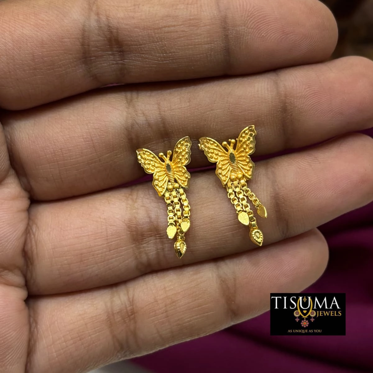 Gold-tone butterfly earrings with hanging chains and decorative leaf charms