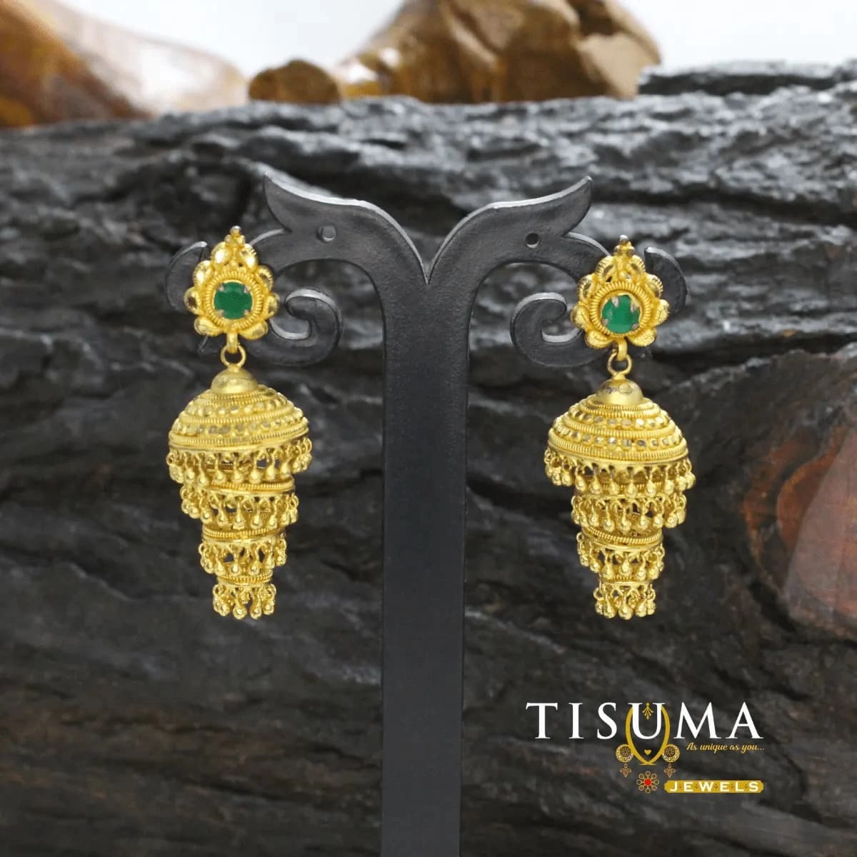 Gold-tone multi-layer jhumka earrings with green centre stones and intricate tiered drops