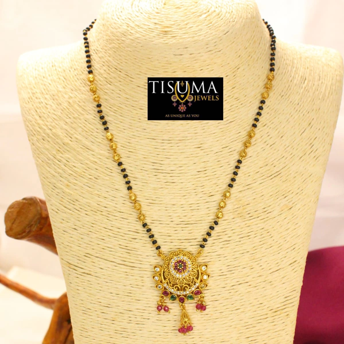 Black beads mangal sutra with gold-finish floral pendant and pink green stones