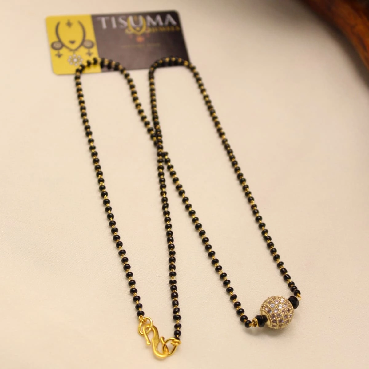 Black beads mangal sutra with round gold-tone AD stone ball pendant
