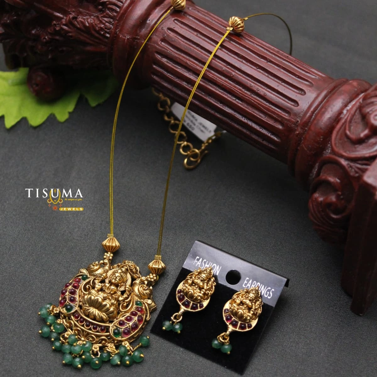Antique gold-tone Lakshmi pendant chain set with ruby-red and green stones and matching earrings