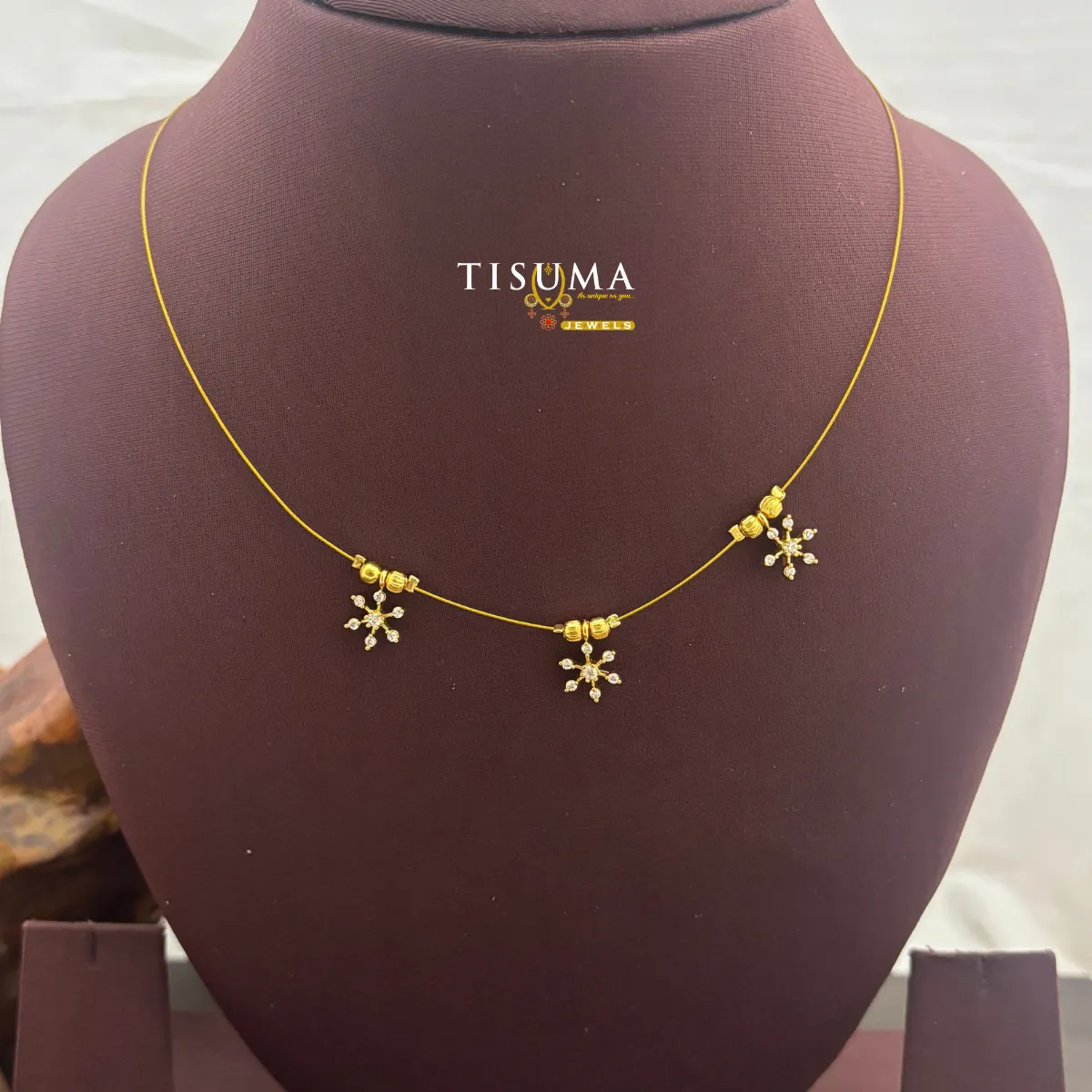 Gold-tone invisible chain with three snowflake-style clear crystal drops