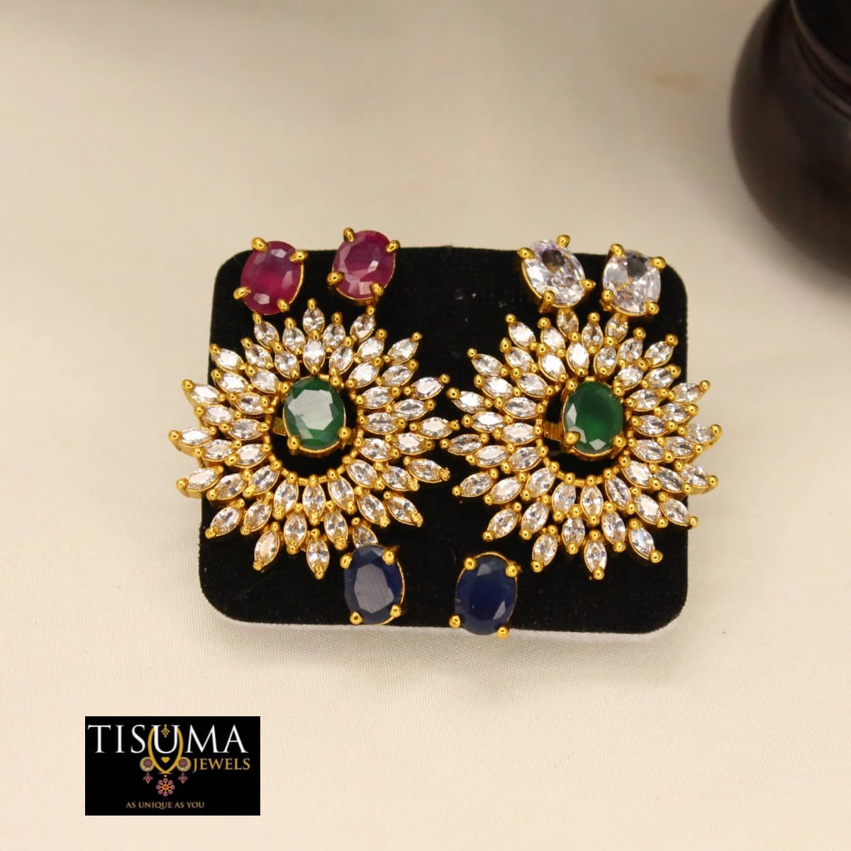 Gold-tone floral AD stud earrings with green centre stones and clear stone accents