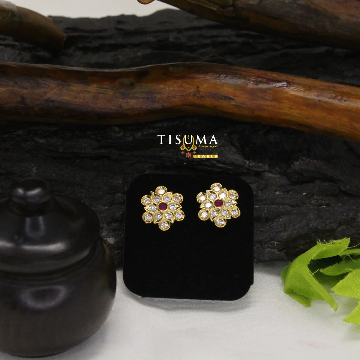 Gold-tone floral stud earrings with ruby-red centre stones and clear