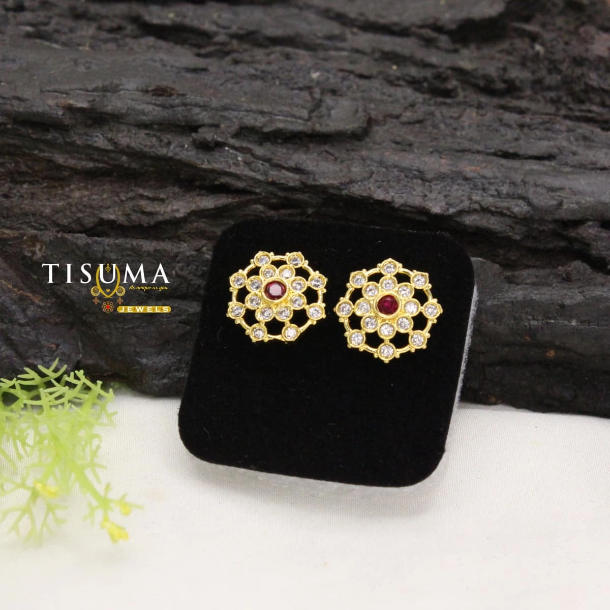 Gold-tone floral stud earrings with ruby-red centre stones and white stone detailing