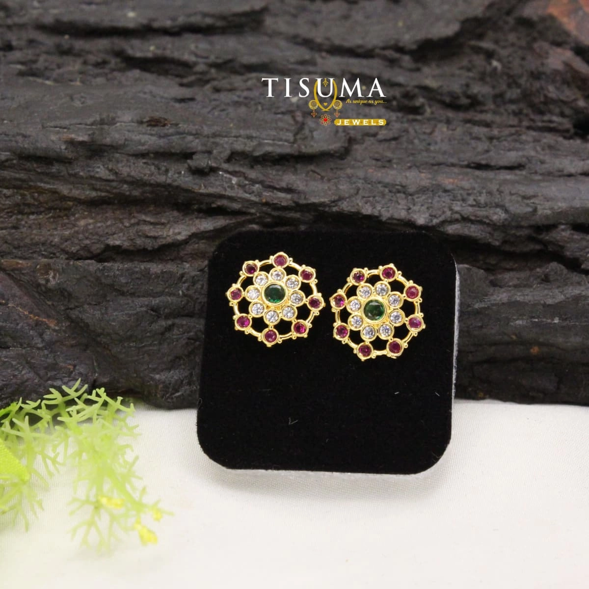 Gold-tone circular floral stud earrings with green centre stones, ruby-pink stones and white accents