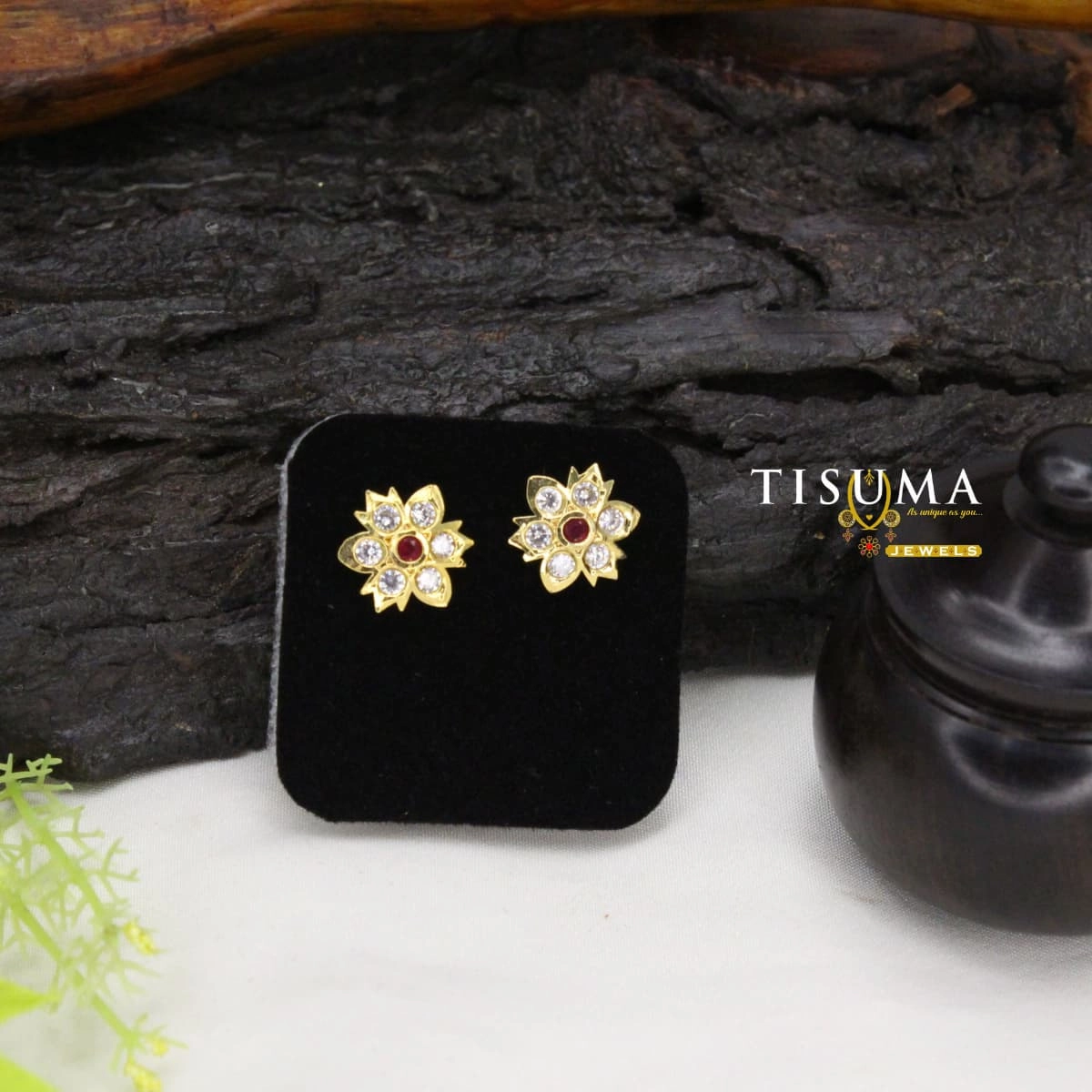 Gold-tone floral stud earrings with ruby-red centre and white stones
