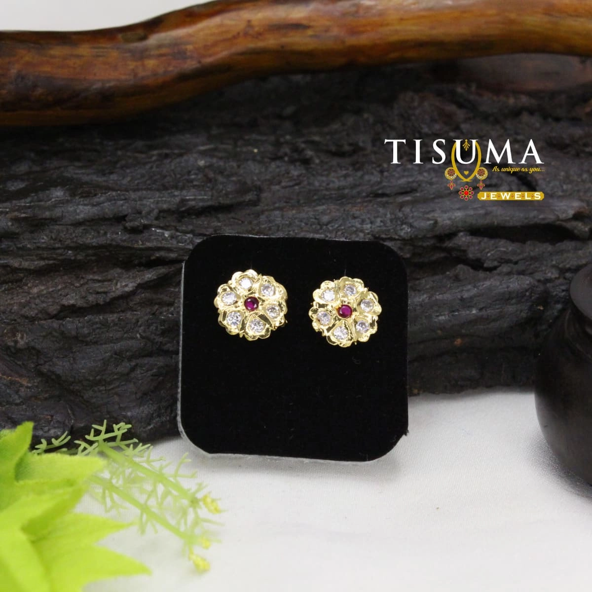 Gold-tone floral stud earrings with a ruby-pink centre stone and sparkling white AD-style stones