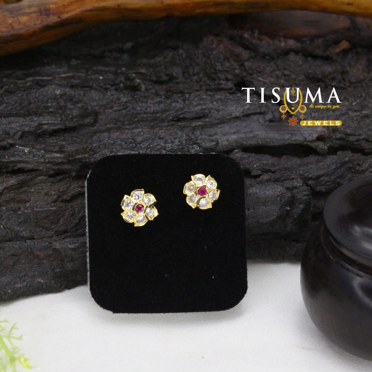 Gold-tone floral stud earrings with a ruby-pink centre stone and white AD-style stones
