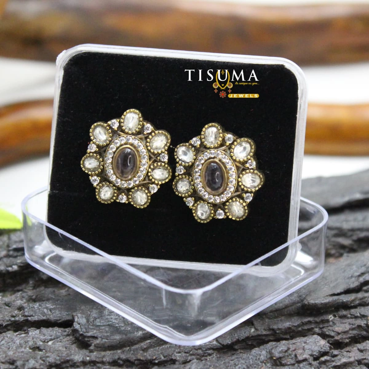 Antique gold floral stud earrings with oval grey-brown centre stones and white AD-style accents