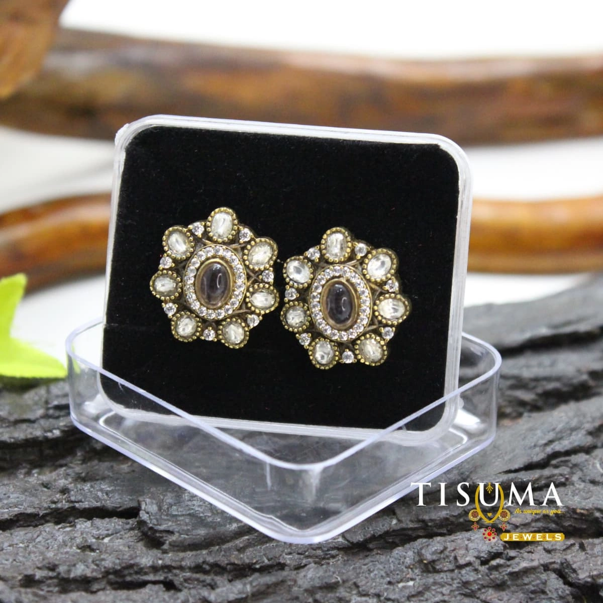 Antique gold-tone floral stud earrings with a dark oval centre stone and white stone accents