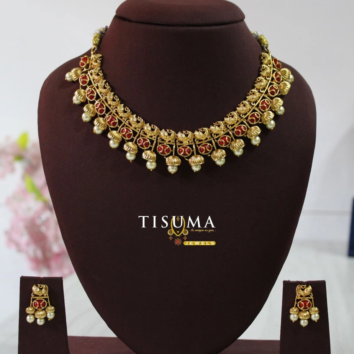 Traditional antique gold finish necklace with red stone detailing, gold motifs, pearl drop accents, and matching earrings – Tisuma Jewels.