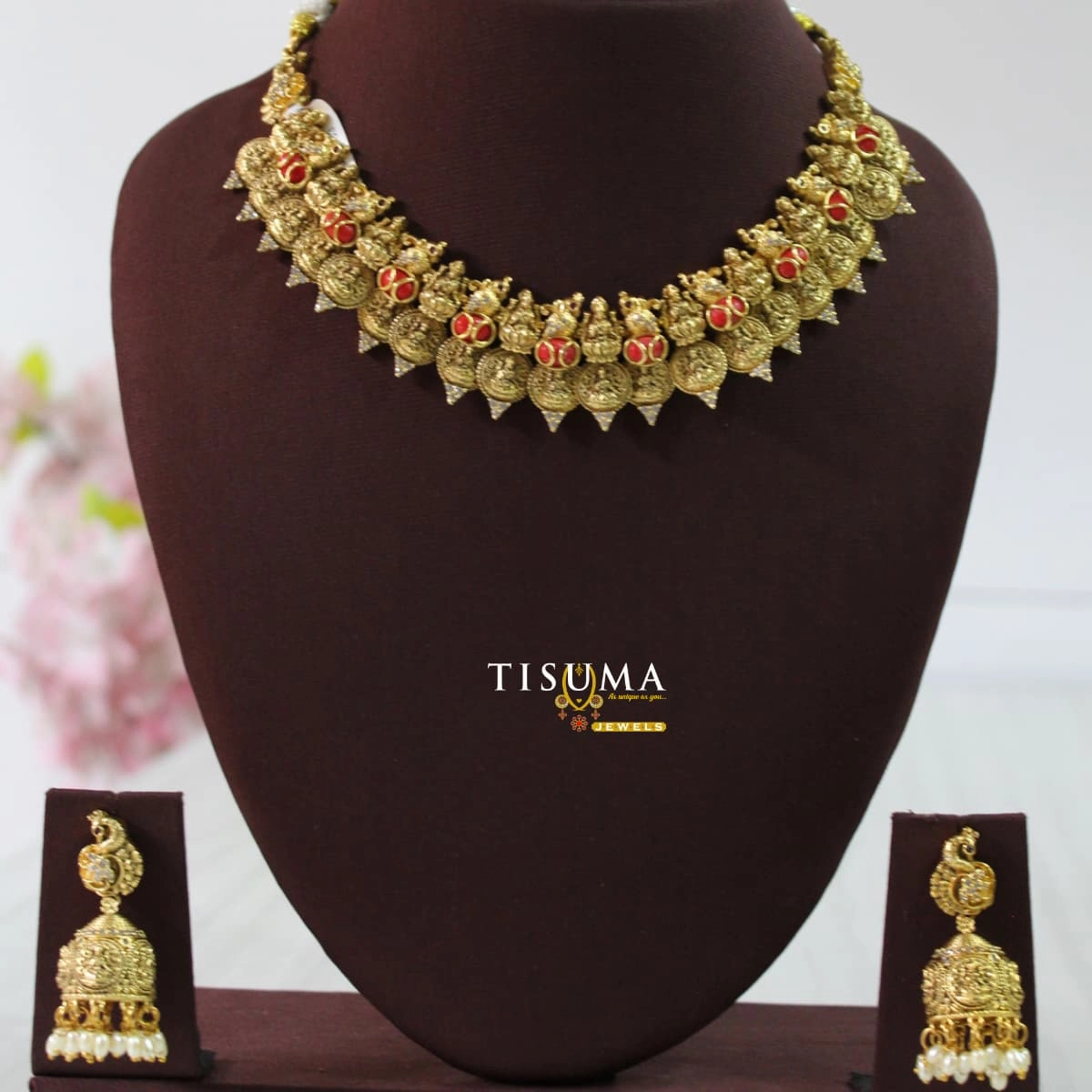 Traditional antique gold finish necklace with red stones, intricate temple-style motifs and matching jhumka earrings with pearl drops – Tisuma Jewels.