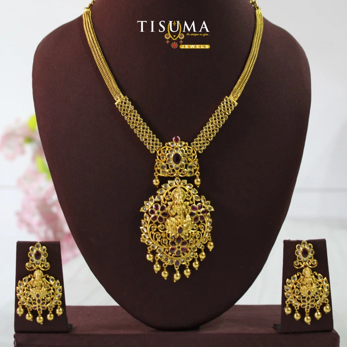 Antique gold Lakshmi pendant necklace set with matching earrings and maroon stone accents