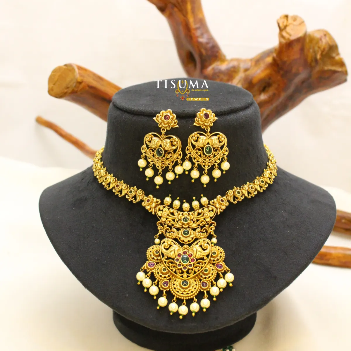 Antique gold-tone bridal necklace with ornate pendant, ruby-pink and green stone accents, pearl-style drops and matching earrings