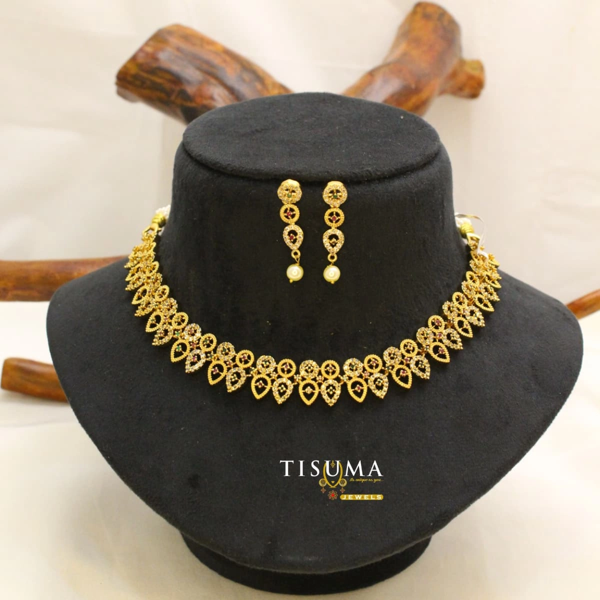 Antique gold-tone AD necklace set with ruby red stones, teardrop floral detailing and matching pearl drop earrings | Tisuma Jewels