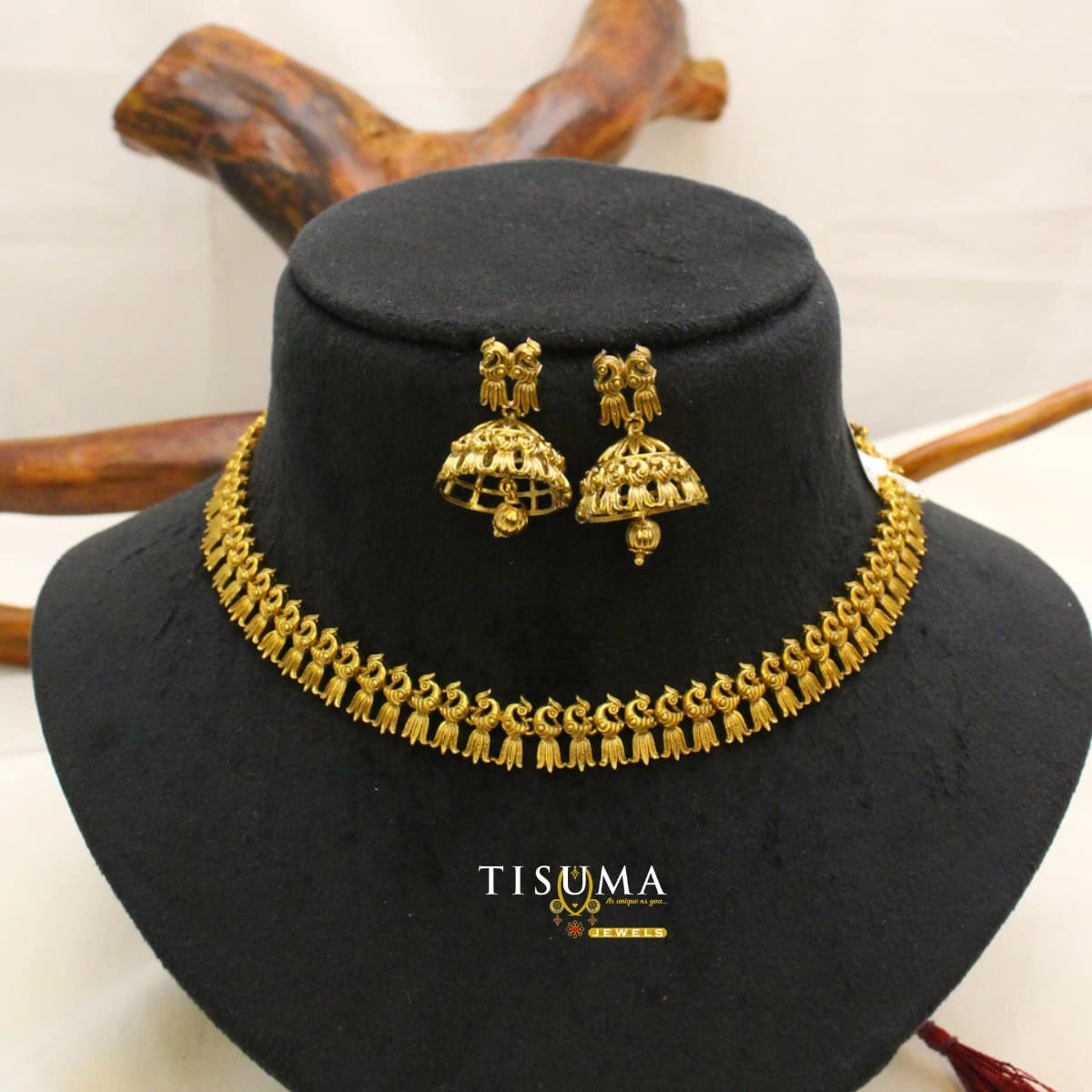 Traditional antique gold-tone matte necklace set with intricate peacock-inspired motifs and matching jhumka earrings | Tisuma Jewels