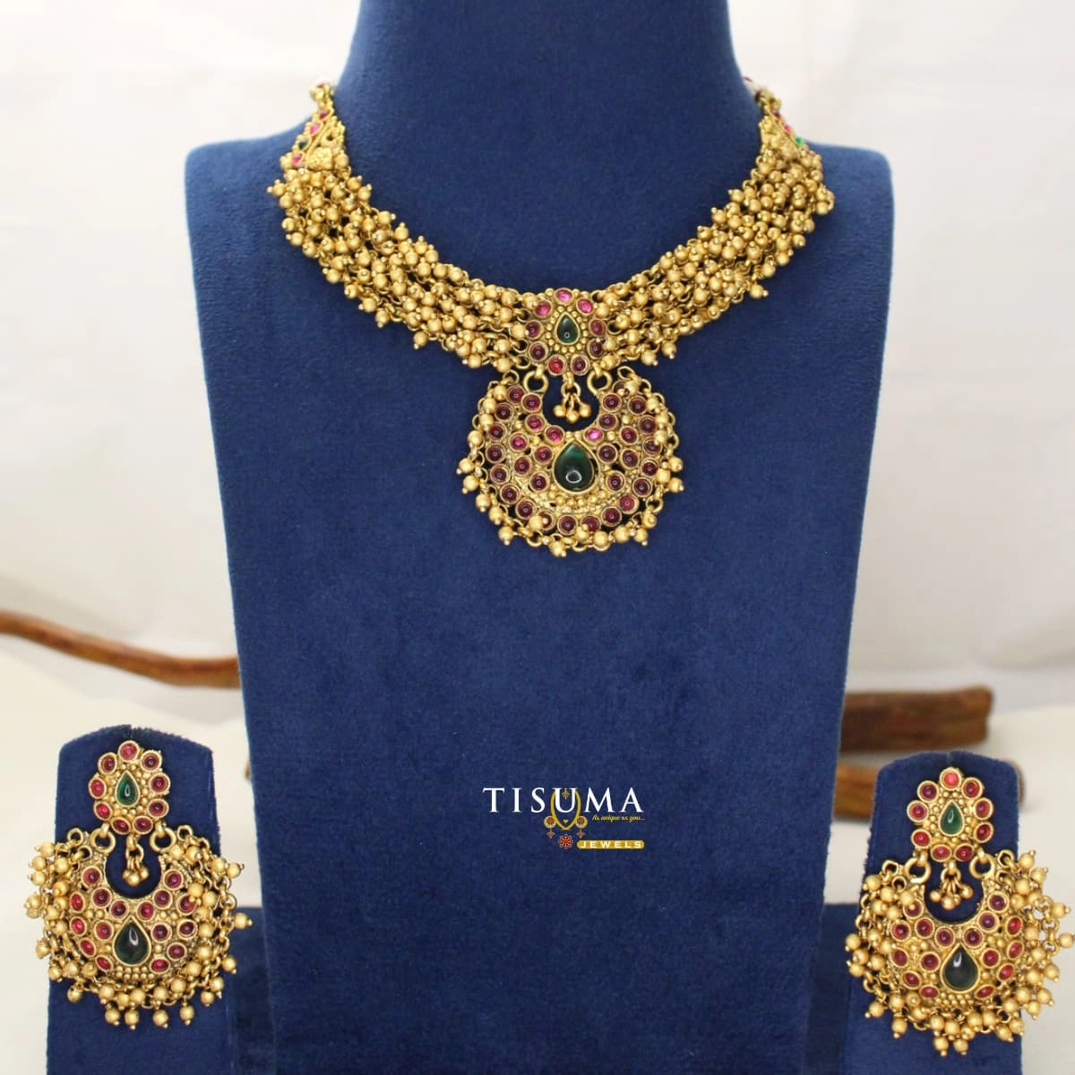 Traditional antique gold-tone matte necklace set with ruby-red and green stones, gold bead detailing and matching earrings | Tisuma Jewels