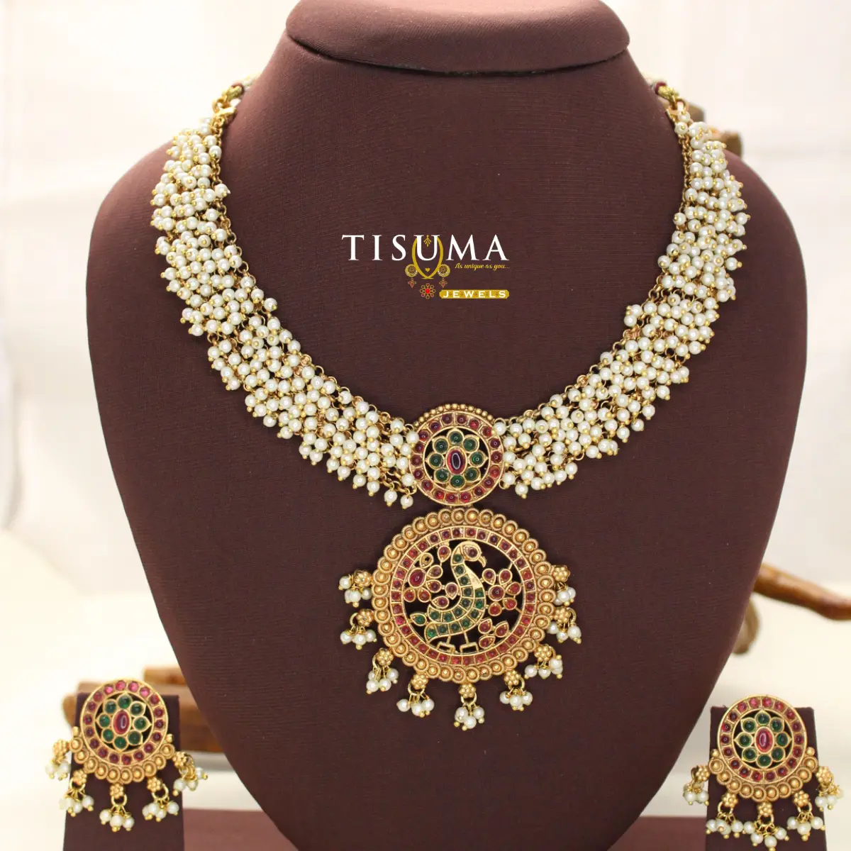 Tisuma Jewels gold plated temple necklace set with white pearl strands, multicolour stone peacock pendant and matching earrings