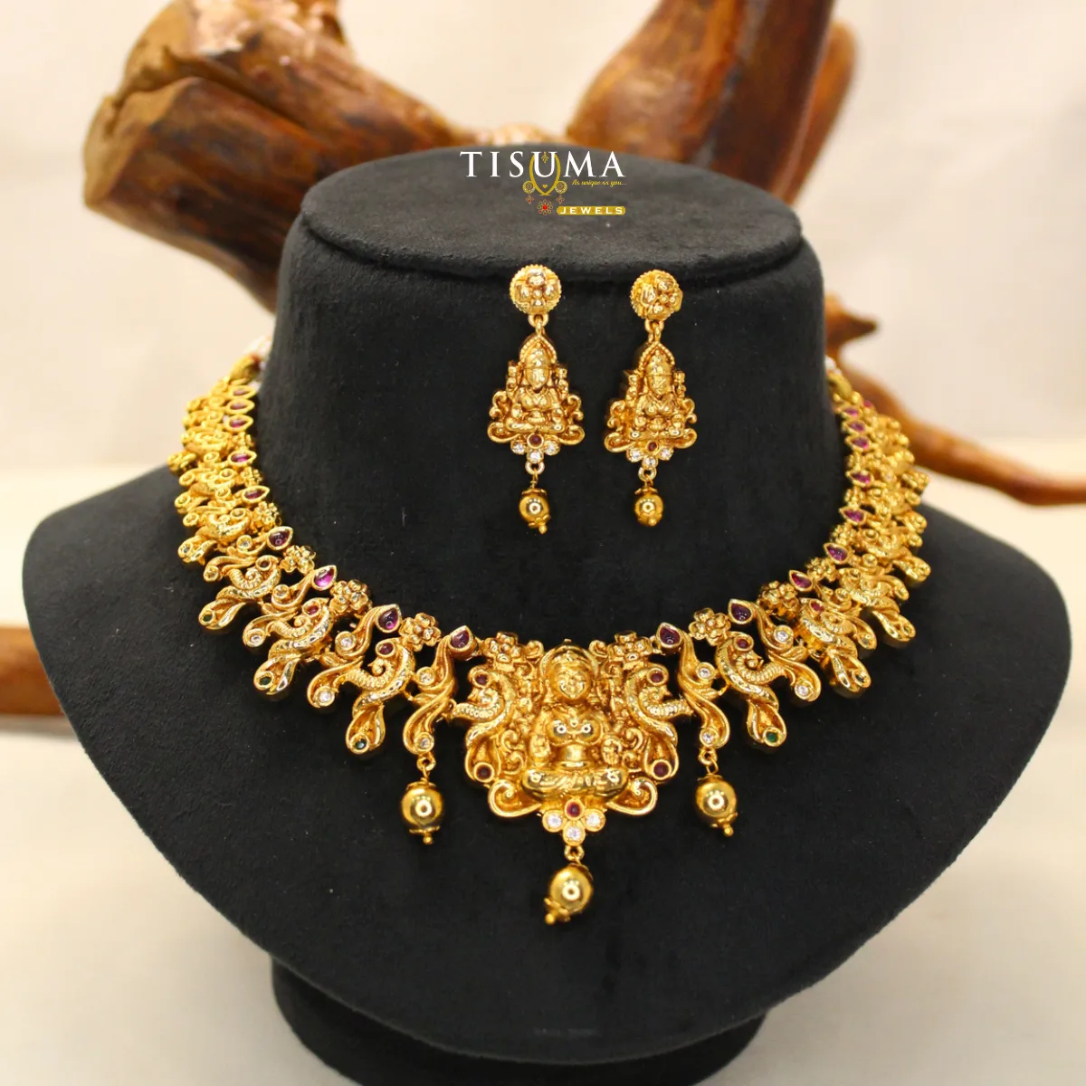 Gold finish Lakshmi temple necklace set with ruby and white stone detailing and matching earrings by Tisuma Jewels