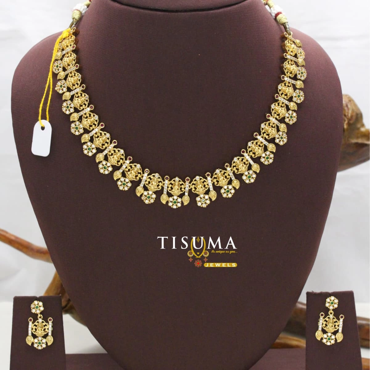 Gold finish traditional Lakshmi necklace set with green and white stone floral accents and matching earrings by Tisuma Jewels