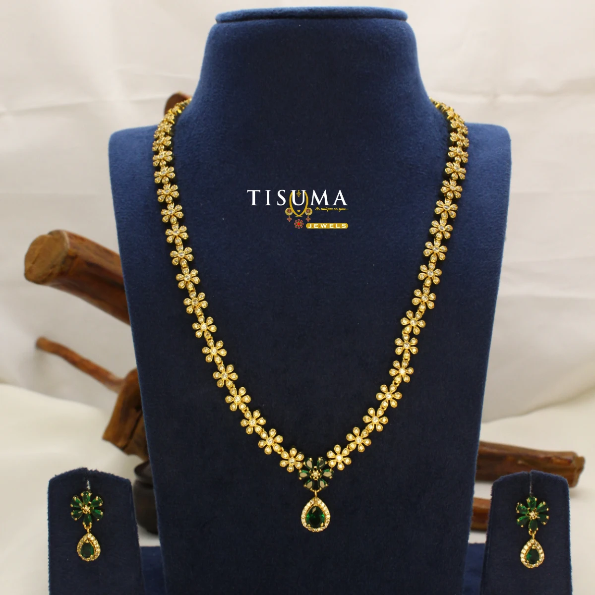 Tisuma Jewels gold-plated floral haram necklace set with green teardrop stones and matching earrings.