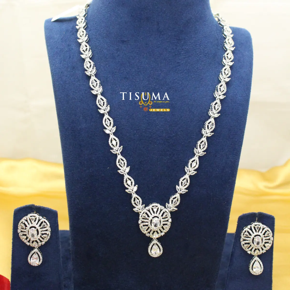 AD silver haram necklace set with leaf pattern, round floral pendant and matching teardrop earrings