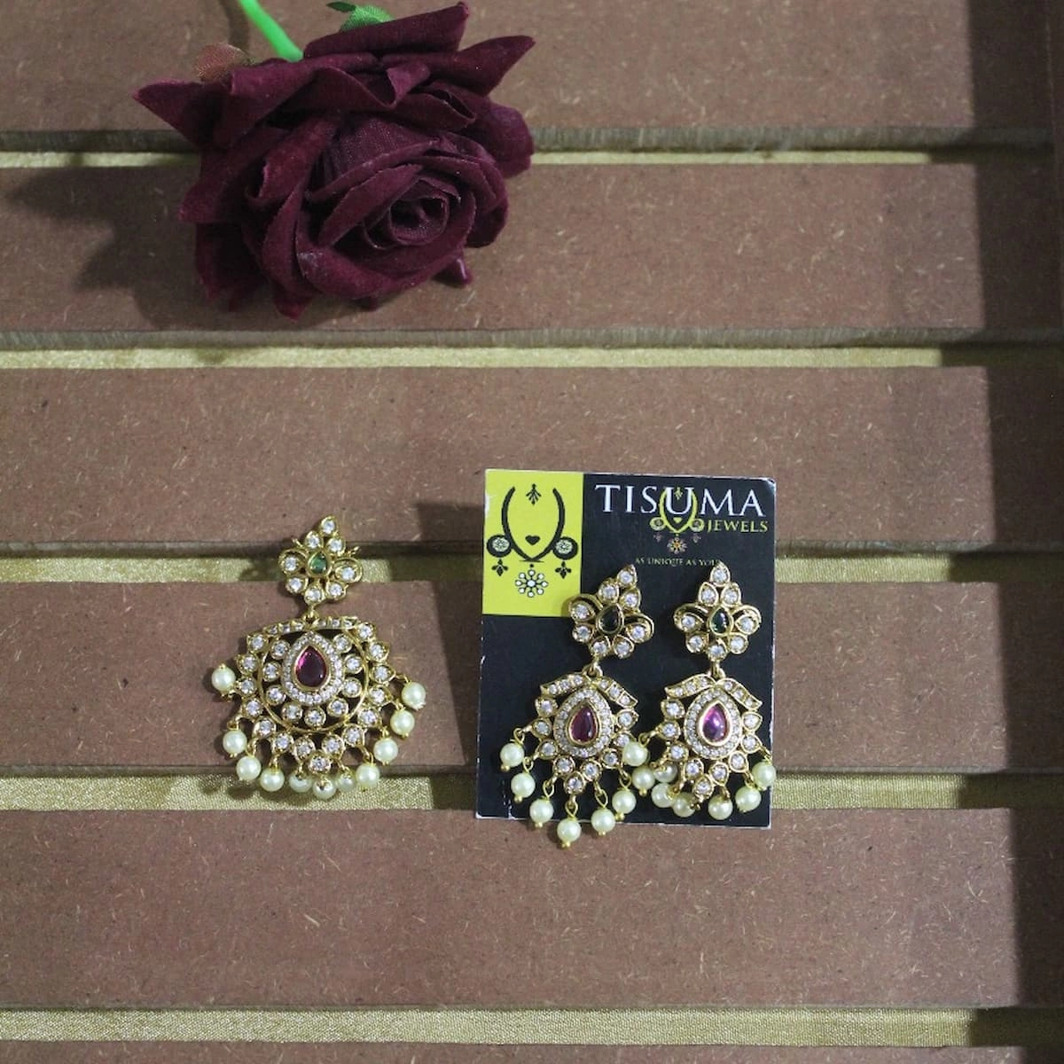 Traditional gold-plated stone-studded earrings with matching pendant featuring ruby-red and green stones and pearl drops by Tisuma Jewels