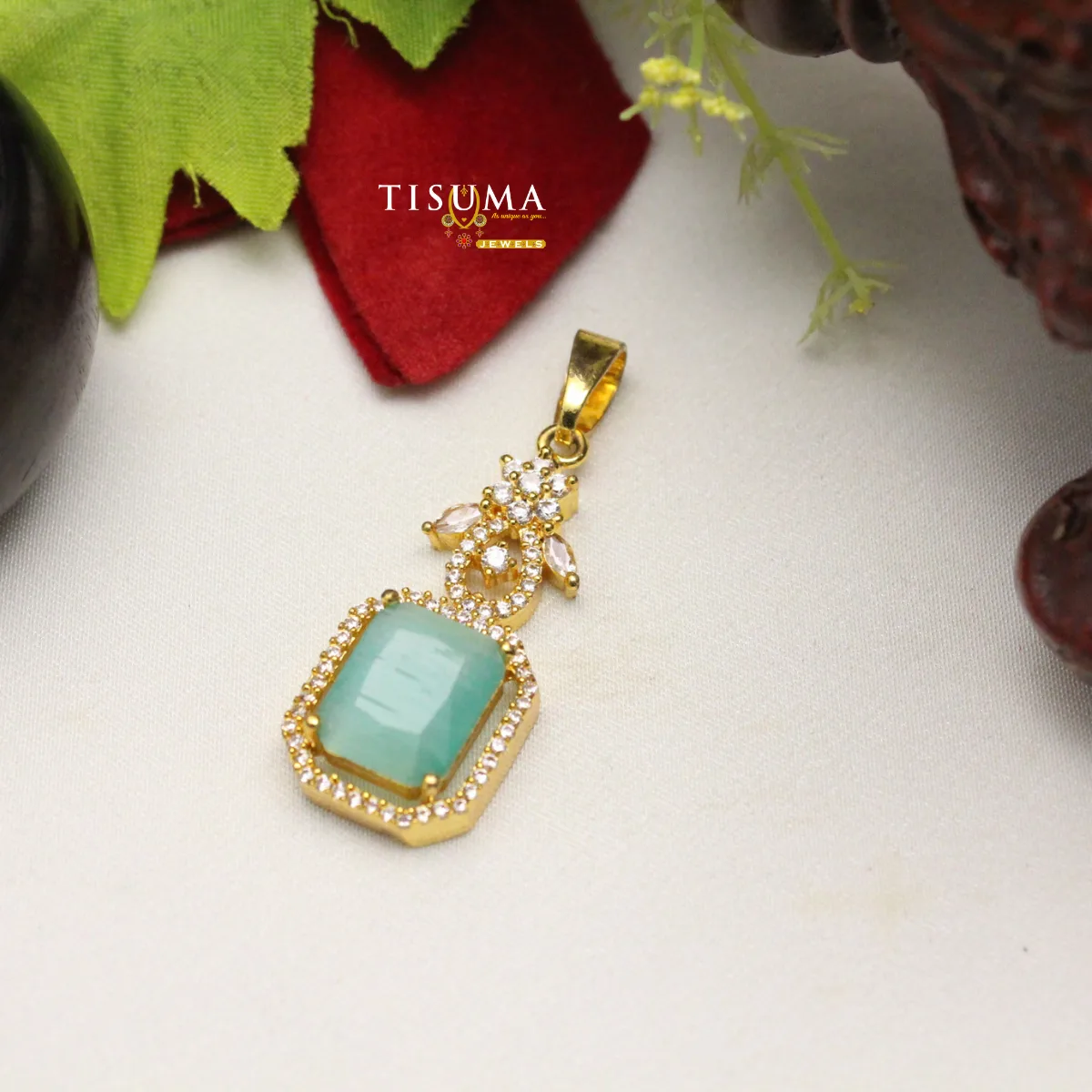 Gold-tone pendant with aqua green rectangular stone and white stone border