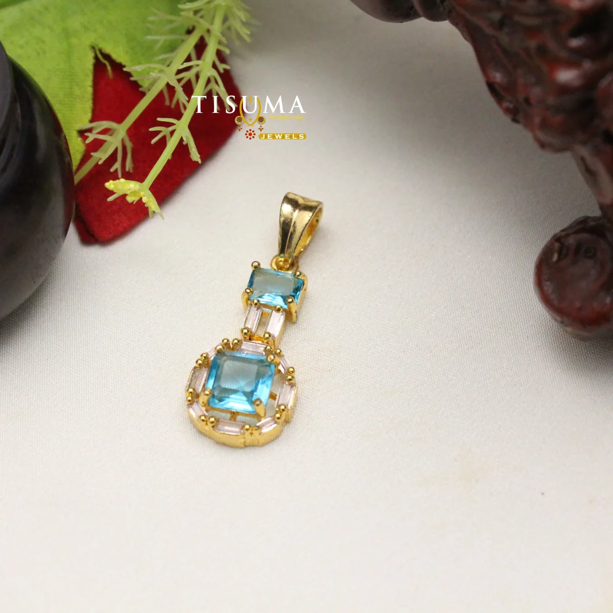 Gold-tone pendant with blue rectangular stones and pale pink accent stones