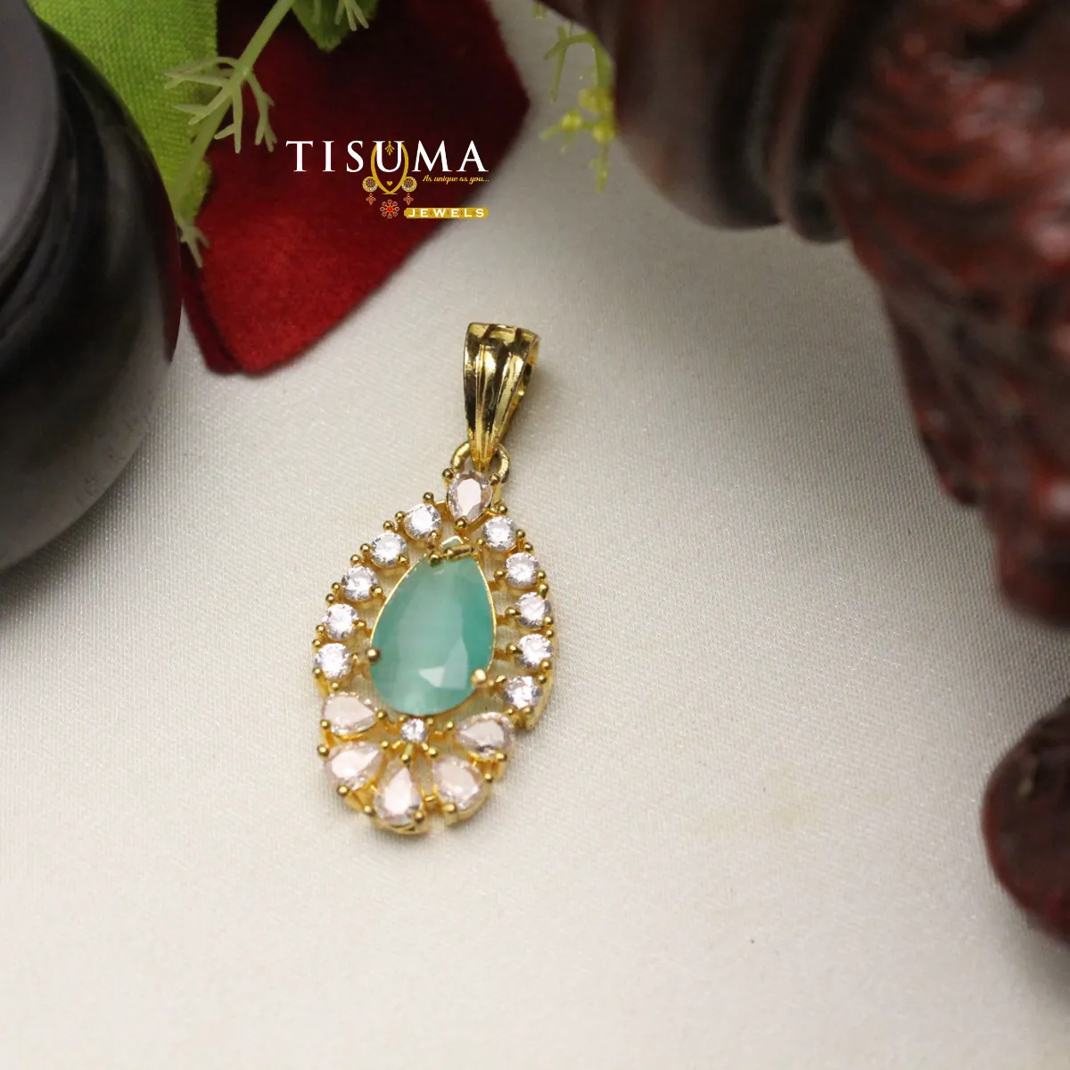 Gold-tone pendant with mint green teardrop stone and white and pink accents