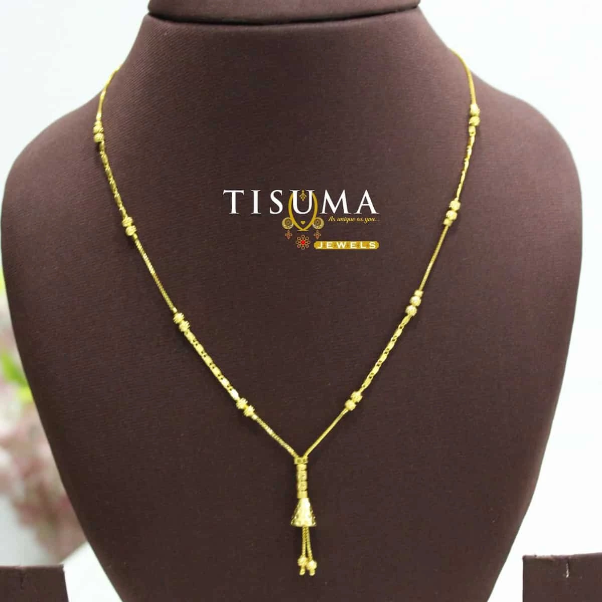Tisuma Jewels gold-tone forming necklace with decorative chain accents and cone-shaped tassel pendant