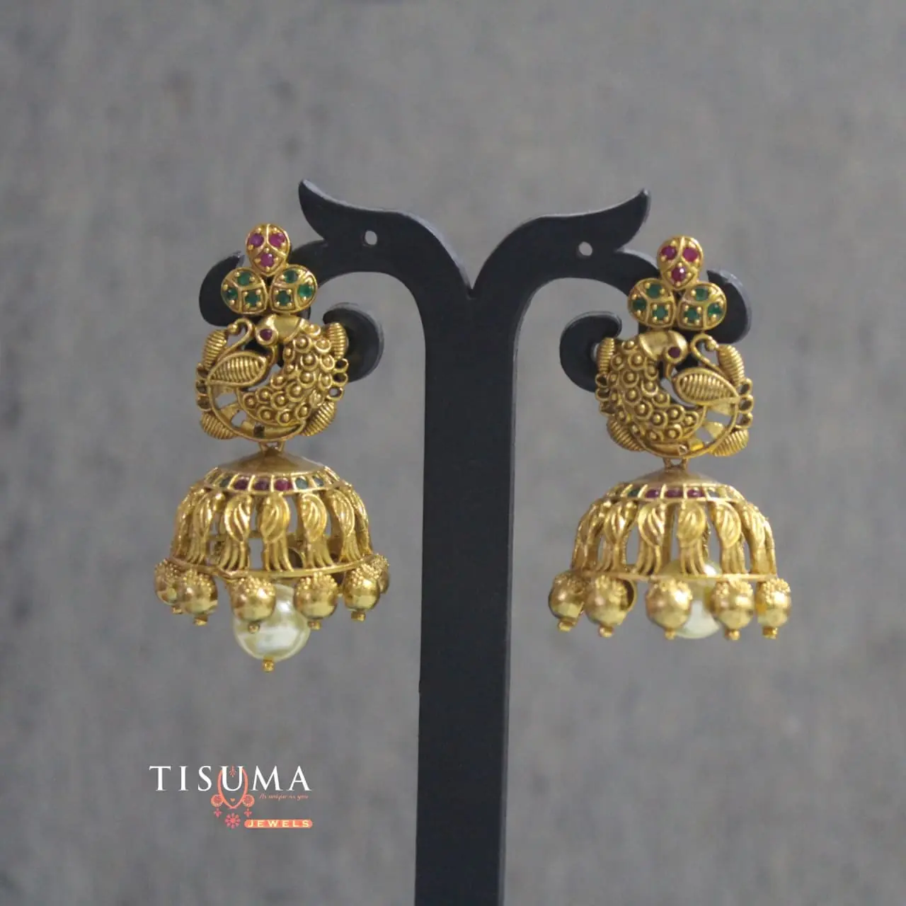 Antique gold-tone peacock matte jhumka earrings with green and pink accents and pearl-style drops